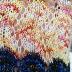 Sample of the Hummingbird Cowl.Knitted in hand-dyed yarn, in reds, yellows and cream
