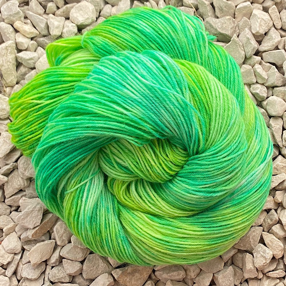 a swirl of BFL/Nylon yarn in Colour: Zesty. pale to bright, deep greens