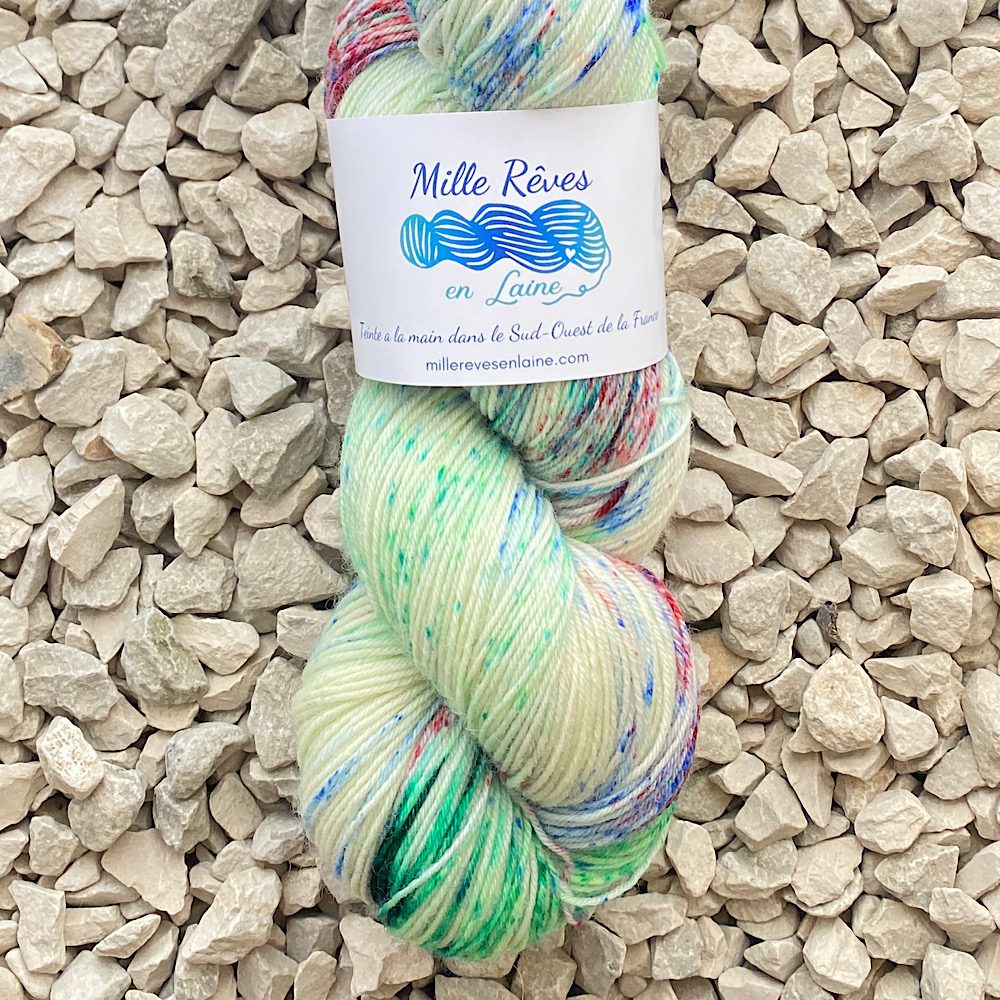 A skein with label. 100% BFL heavily specked in red, blues and greens