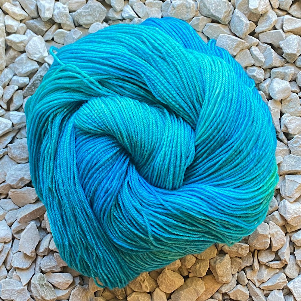 A swirl of hand-dyed yarn in sea blues and greens