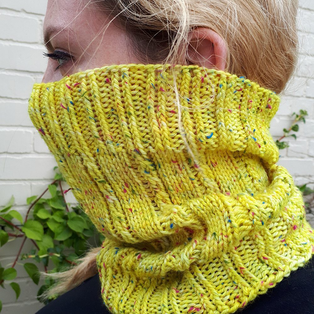 Woman wearing Tram Tracks Cowl, knitted in yellow wool