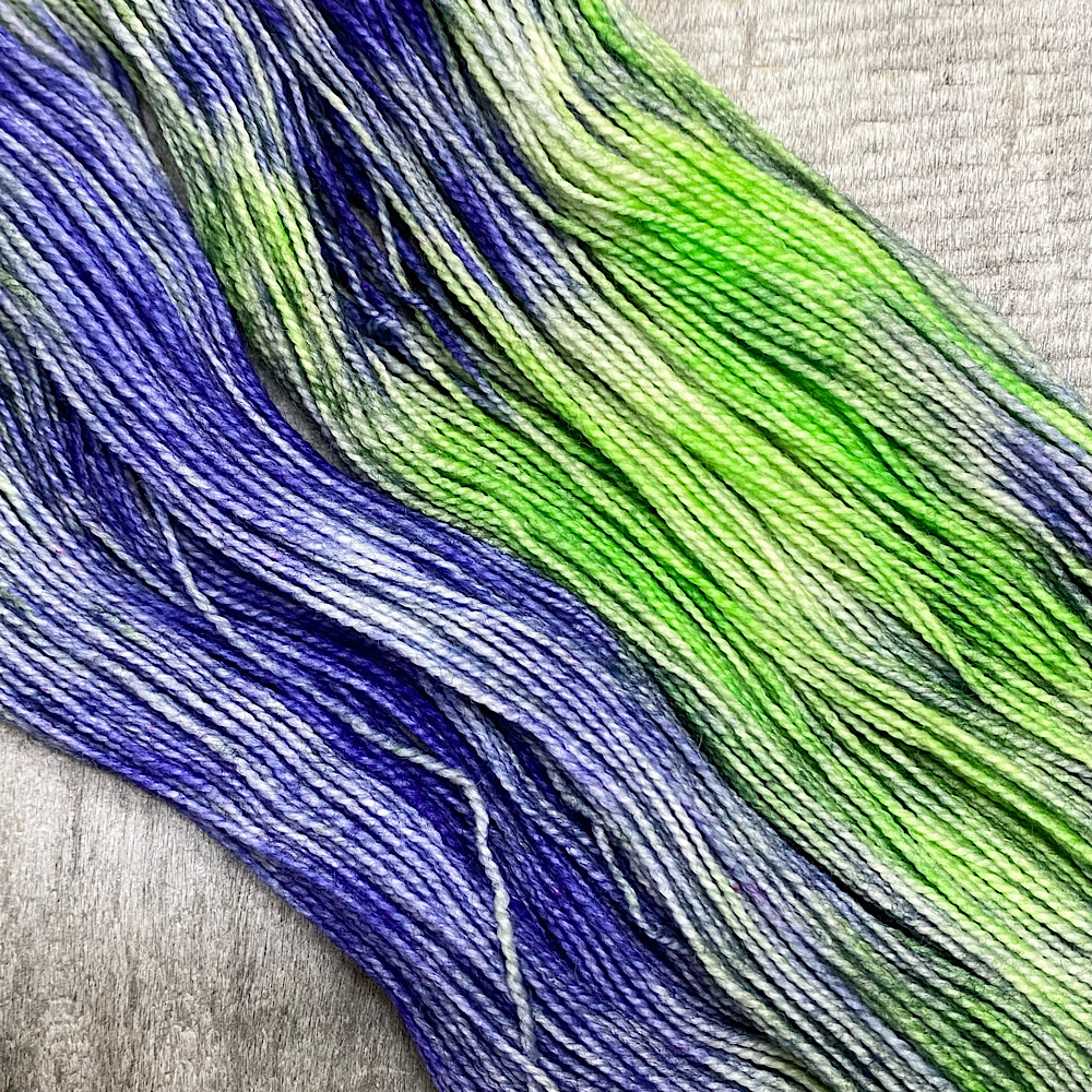 Hand dyed pure BFL wool, spun with a twist, in colour 'Lilac Field'. Shown arranged flat and spread out to show the colours clearly,