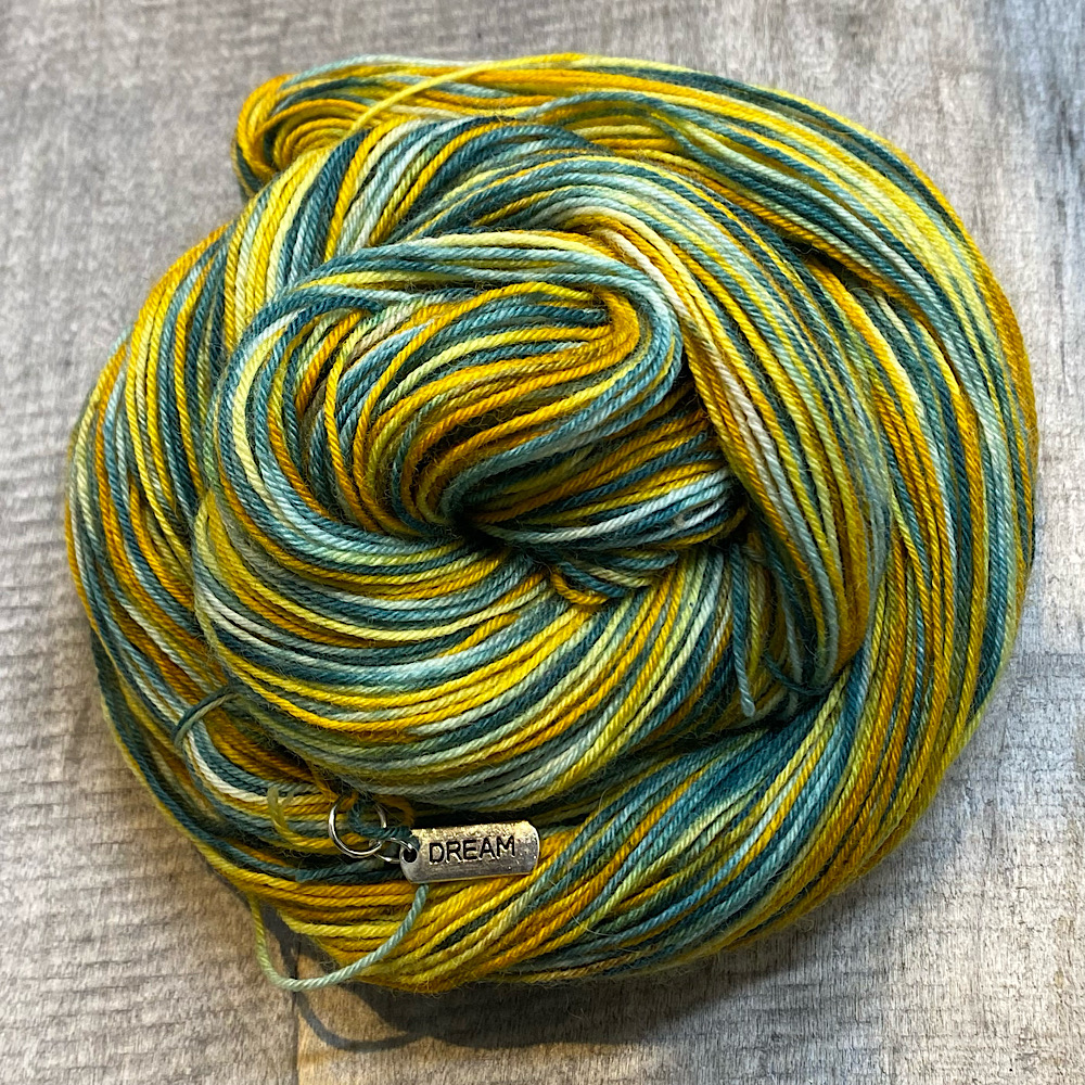 Photograph of hand dyed BFL wool in 'Trent Bridge. Arranged in a swirl. The colours are taken from the actual Trent Bridge in Nottingham, in England.