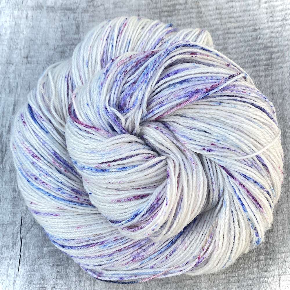 BFL 'Multi-Speckles' with blue and pink speckles on bare woolshown in a swirl shape.