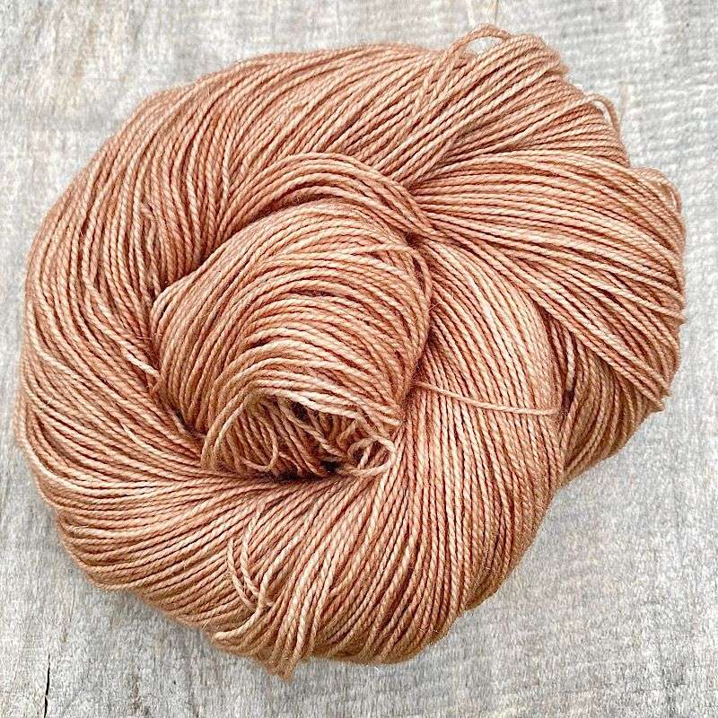 A swirl of hand dyed yarn in 'Iced Latte'. a milky coffee coloured semi-solid colour